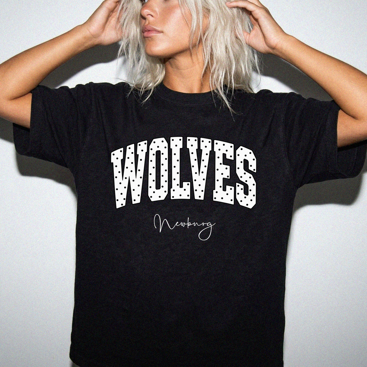 Newburg Wolves white polka-dot varsity graphic shown on black T-shirt