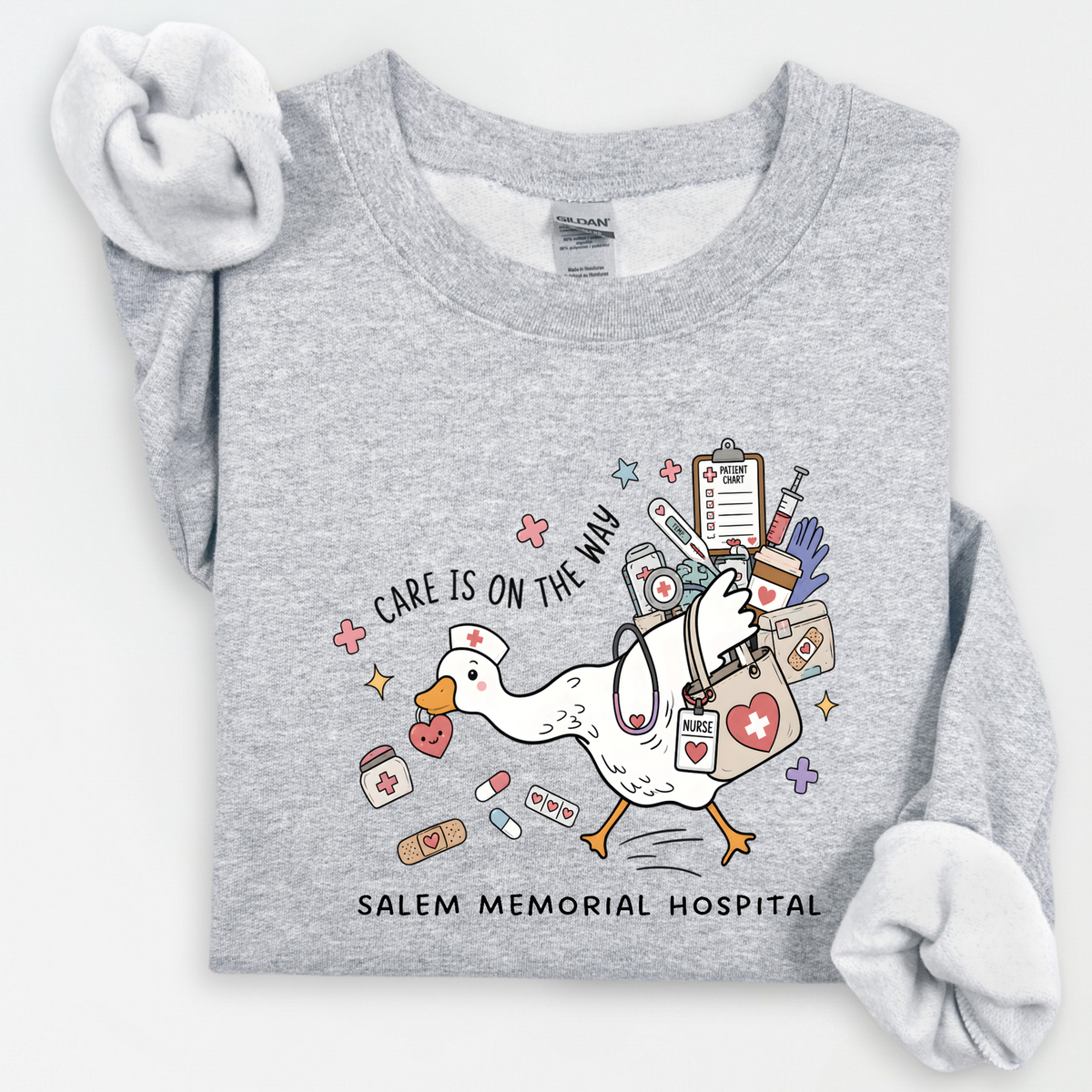 Care Is on the Way nurse goose design with Salem Memorial Hospital lettering on a sport grey crewneck sweatshirt